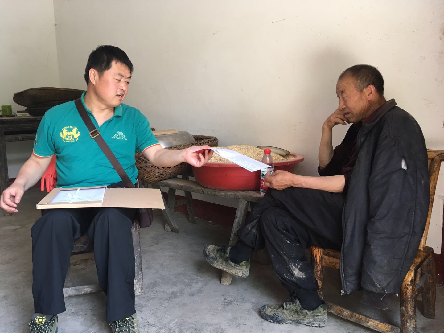 执行庭庭长冯涛在贫困户倪文必家中核对扶贫资料信息（胡含如 摄）.jpg