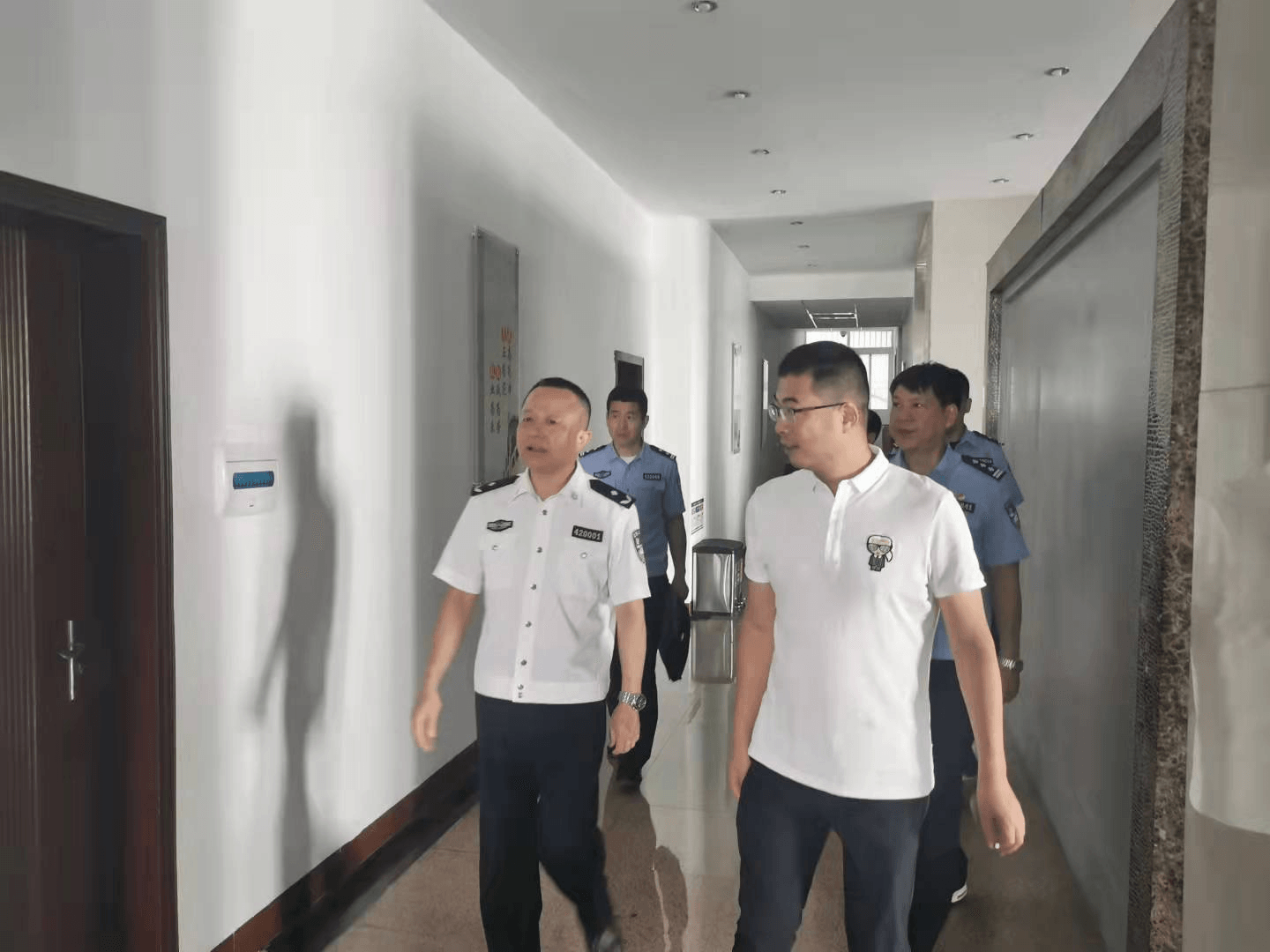 余劲海总队长（左一）与史志高院长（右一）检查办公场所安保设施.png